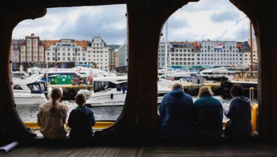 Picture shows five people on Bryggen looking at Vågen 