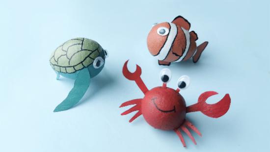 Figurer av papp, en krabbe, en skilpadde og en fisk.